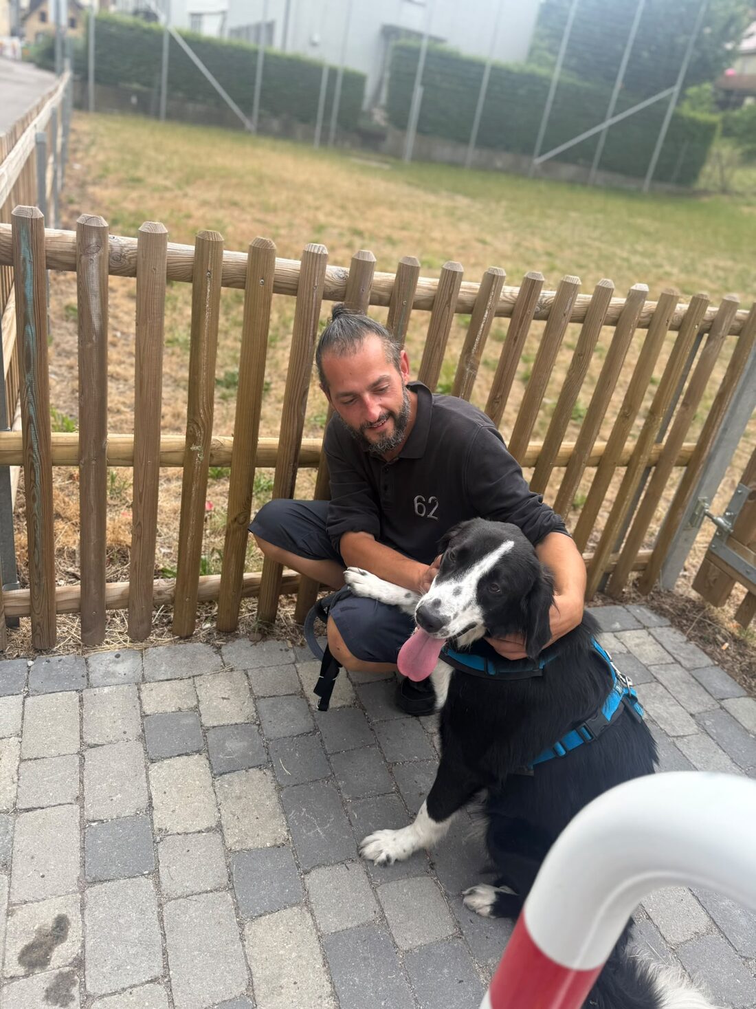 Manuel Rösch mit einem jungen Hund im Garten von Alpha Dogs